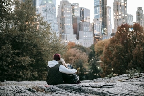 couple sitting on flat rock nyc skyline